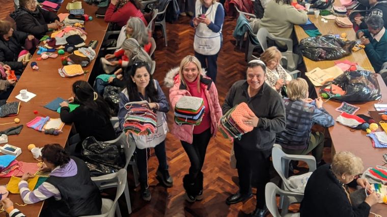 Voluntarios unen cuadraditos de lana para hacer frazadas para los más humildes.