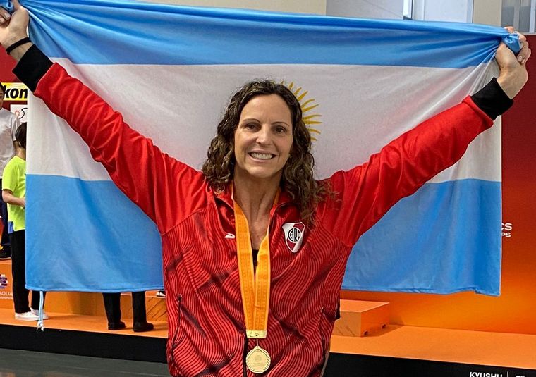 Virginia Garrone, con una de sus medallas doradas y la bandera argentina