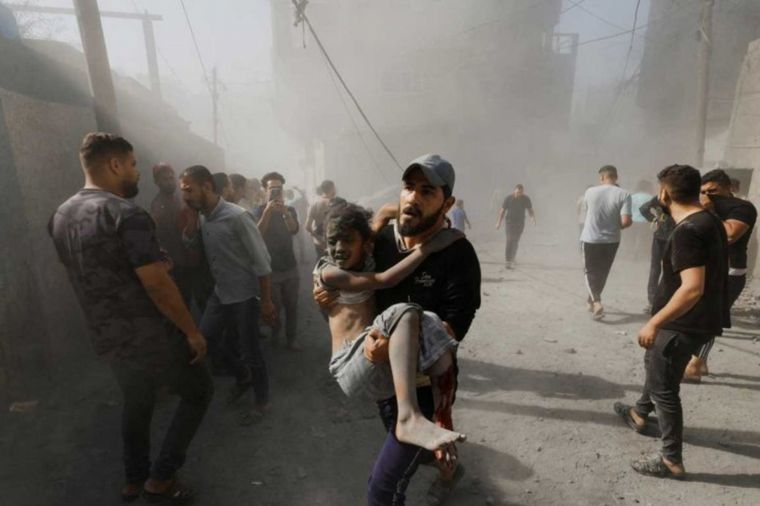 FOTO: Un hombre palestino lleva a una niña herida 