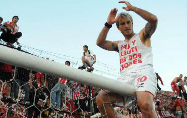 ''La Gata'' Fernández festeja, trepado a un arco, el título del ''Pincha''. 