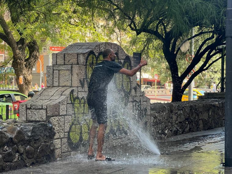 Calor en Córdoba: un vendedor ambulante se refresca en las calles.