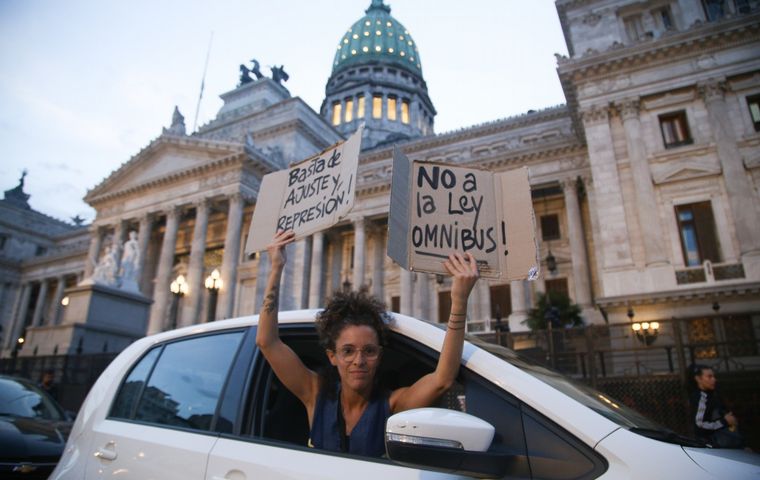 Una manifestante se expresa en contra de la ley ómnibus afuera del Congreso. 