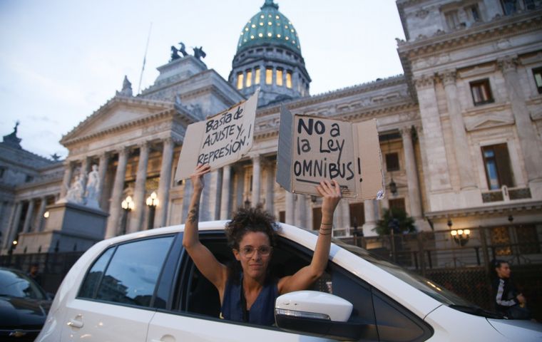 FOTO: Una manifestante se expresa en contra de la ley ómnibus afuera del Congreso. 