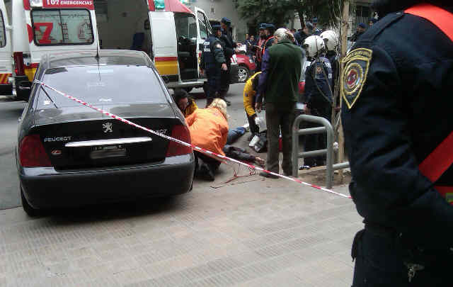 Los servicios de emergencia y policías atienden a uno de los heridos.