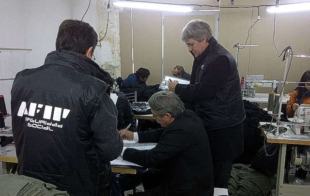 FOTO: Los inspectores de la AFIP en pleno procedimiento en un taller textil clandestino.
