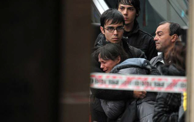 La madre de la víctima llora sin consuelo mientras es consolada por familiares. 