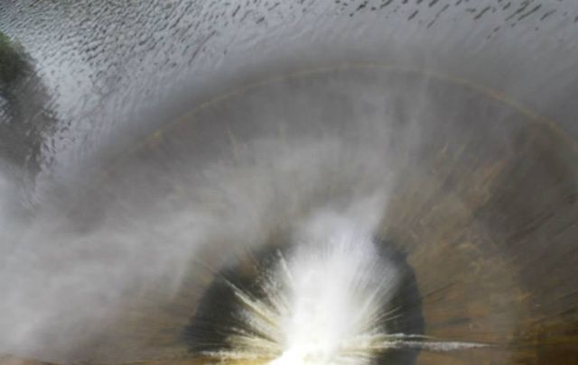 Vista aérea del agua pasando por el vertedero.