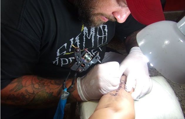 Juan Pablo Rodríguez, concentrado en la realización de un tatuaje.