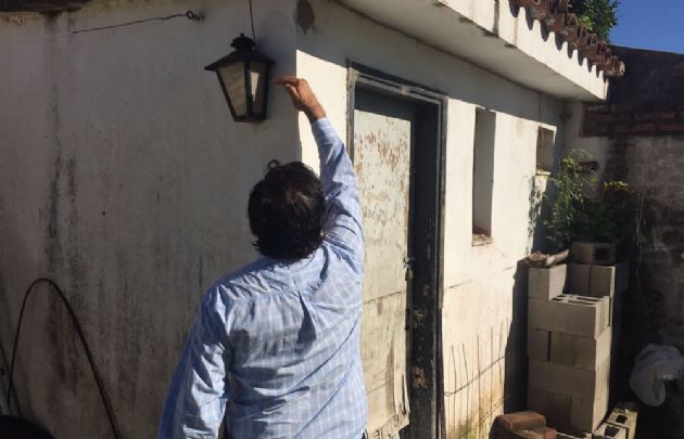 El dueño de casa muestra con la mano hasta dónde llegó el agua.
