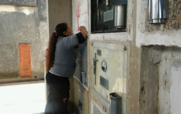 Estela, con un pantalón de Colón, pintando el nicho con los colores de Unión.