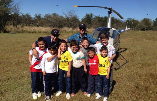 Un grupo de chicos junto al helicóptero en el que cubre la carrera Cadena 3.
