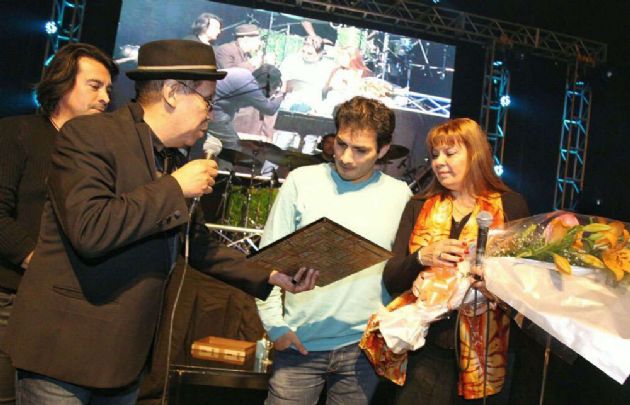 Pelusa entregando una plaqueta a la esposa e hijo de Gary