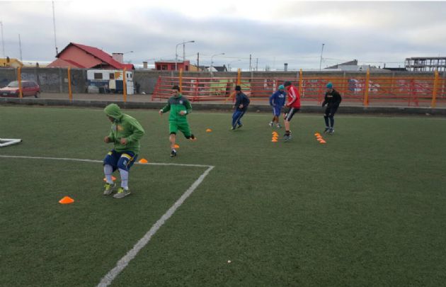 Los jugadores de Camioneros entrenan abrigados por el intenso frío.