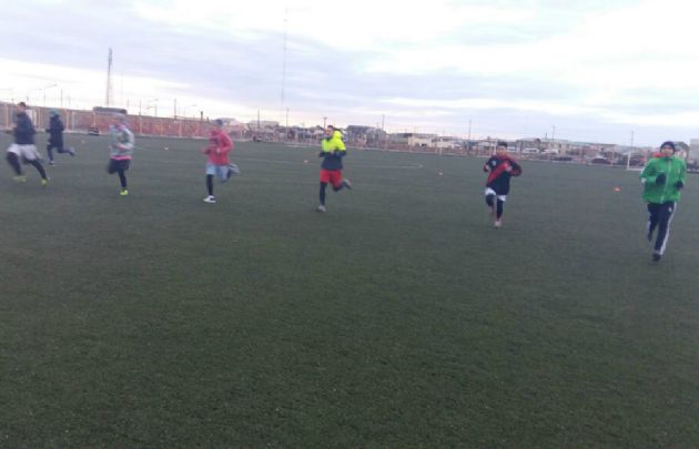 Los jugadores de Camioneros entrenan abrigados por el intenso frío.