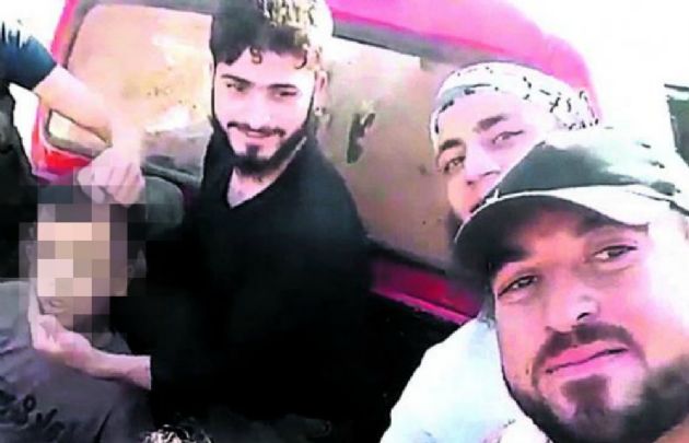 Los rebeldes junto al niño, minutos antes de decapitarlo.