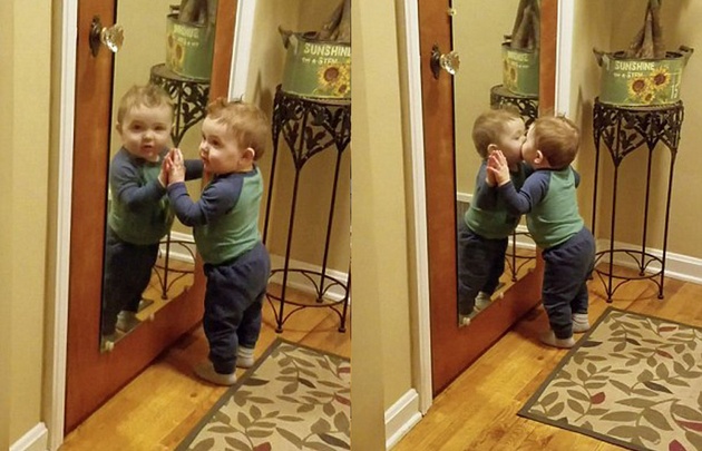 Bebé se besa a sí mismo contra el espejo