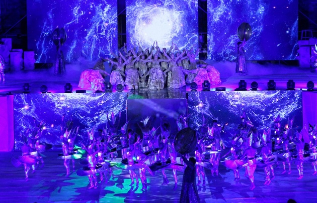 Una gran puesta en escena con bailarines y actores en el teatro griego.