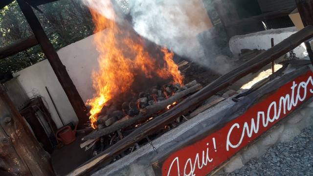 Cocción del curanto, tradición milenaria en Colonia Suiza