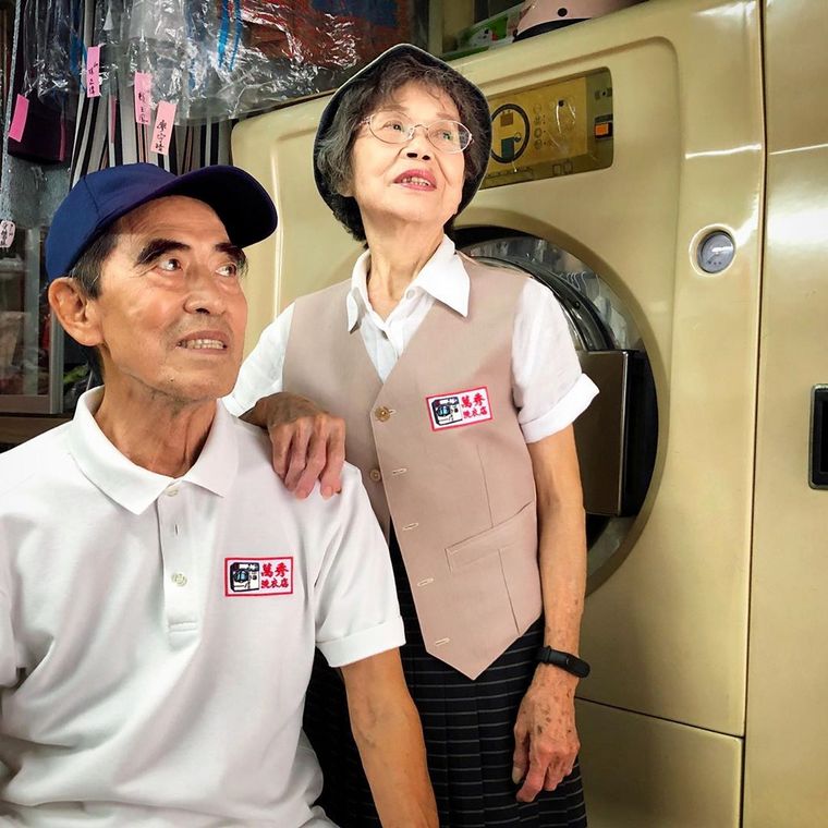 Abuelos posan para su nieto con ropa olvidada en su lavandería.