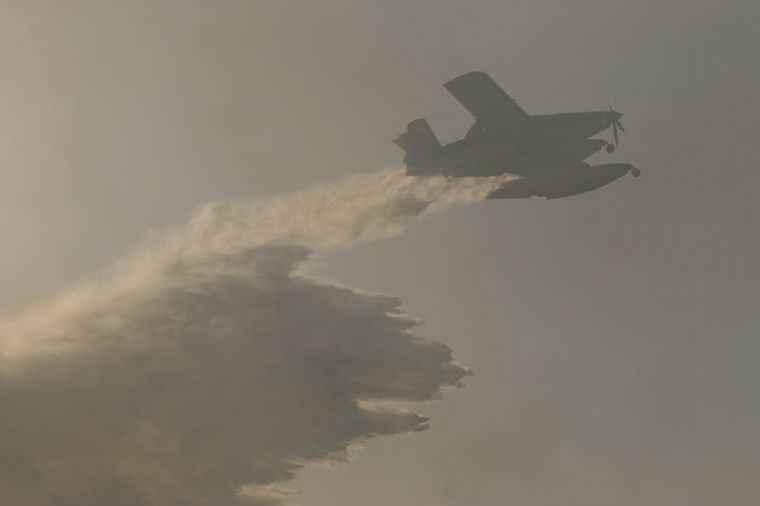 Un avión hidrante colaborando en los incendios.
