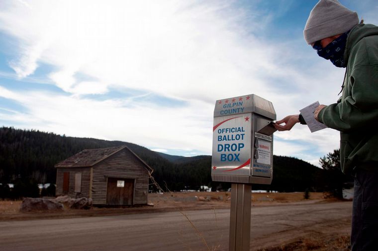Un vecino de Colorado introduce su voto en una casilla postal (Fuente: AFP).
