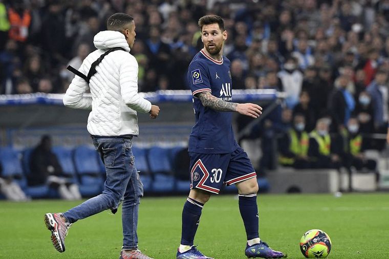 FOTO: Un individuo burló la seguridad e invadió el campo de juego para llegar a Messi. 