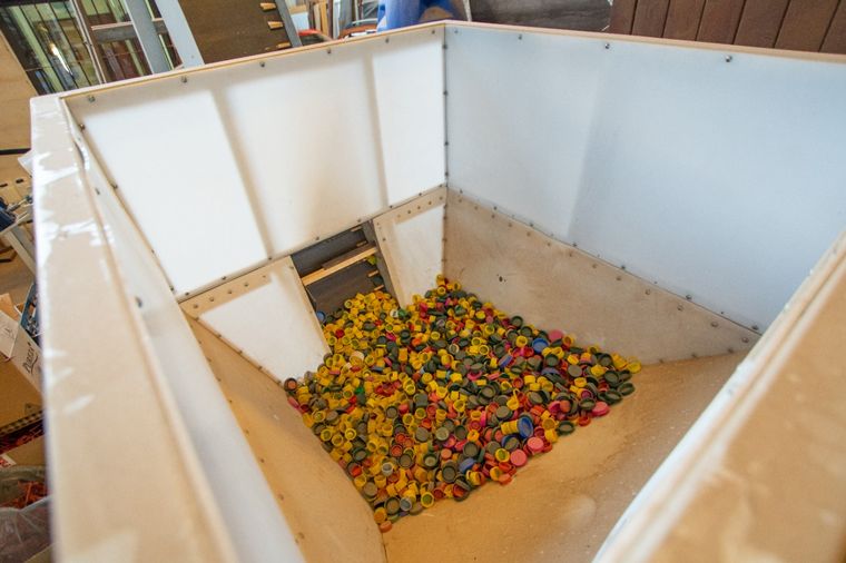 Reciclan tapas de plástico para hacer medallas para maratonistas.