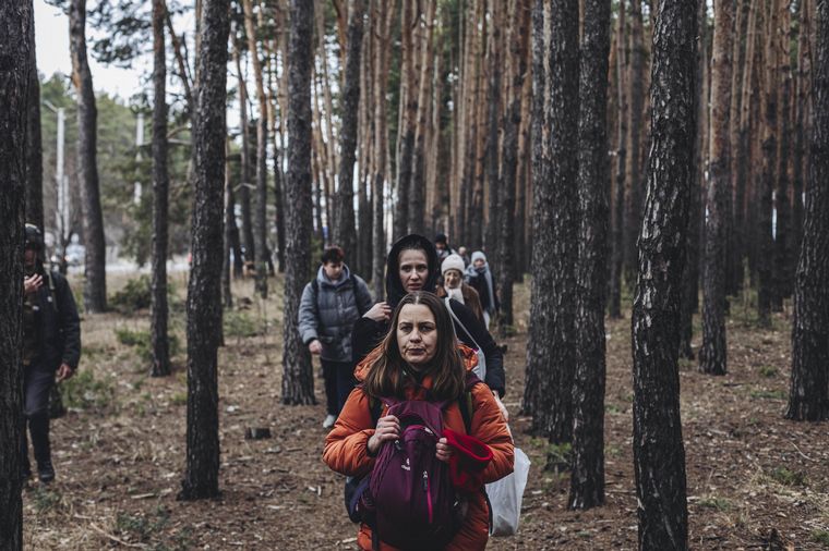 FOTO: Un grupo de civiles ucranianos intenta escapar por un bosque de Irpin. 