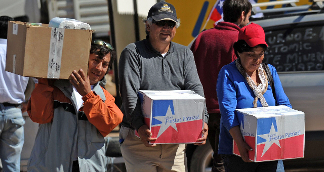 Familiares de los mineros llevan cajas con alimentos y otros elementos para sus seres queridos.