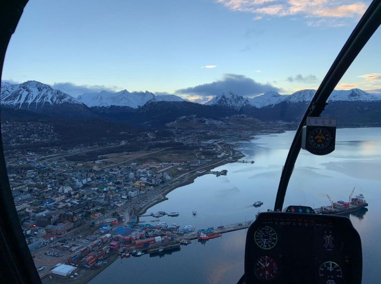 Apreciar Ushuaia nevada desde el cielo a bordo de un helicóptero.