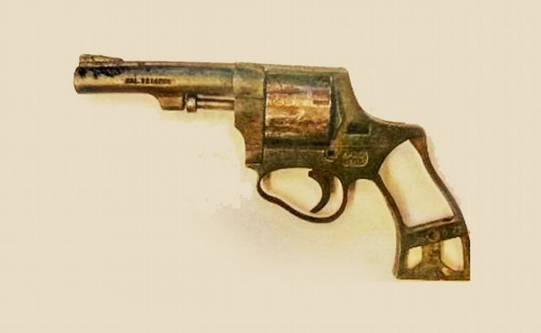 El revólver que los policías llevaban en el patrullero y le 