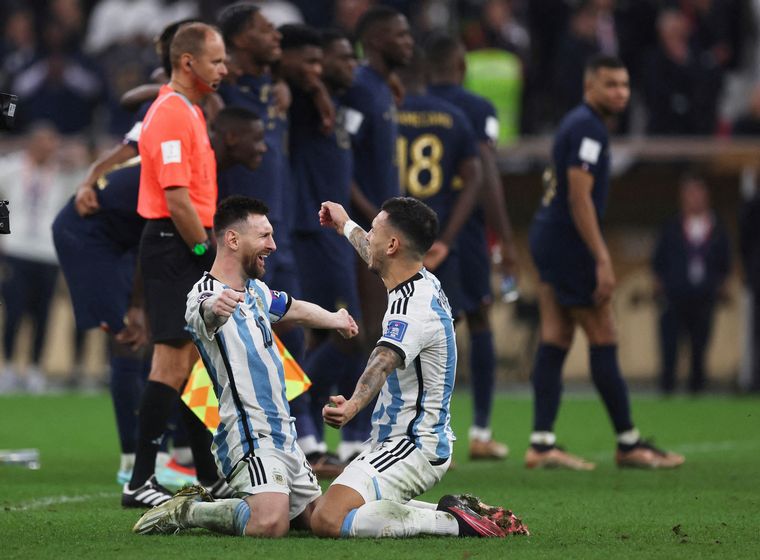 Messi y Paredes se abrazan, arrodillados, tras consagrarse campeones del mundo.