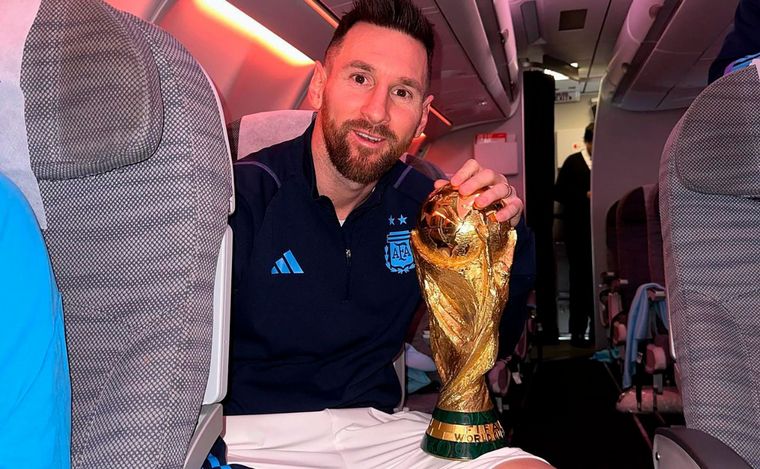 FOTO: Lionel Messi celebra en el vuelo de regreso junto a la Copa del Mundo.