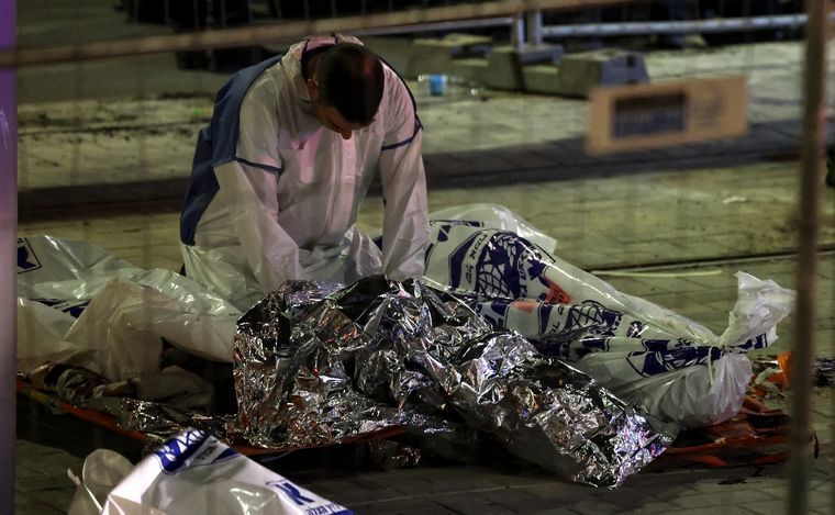 FOTO: Víctimas cubiertas con una manta de aluminio de emergencia yacen en el suelo.
