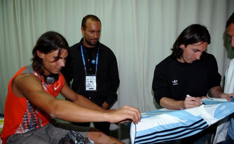 FOTO: Lionel Messi firmándole una camiseta de Argentina a Rafael Nadal.